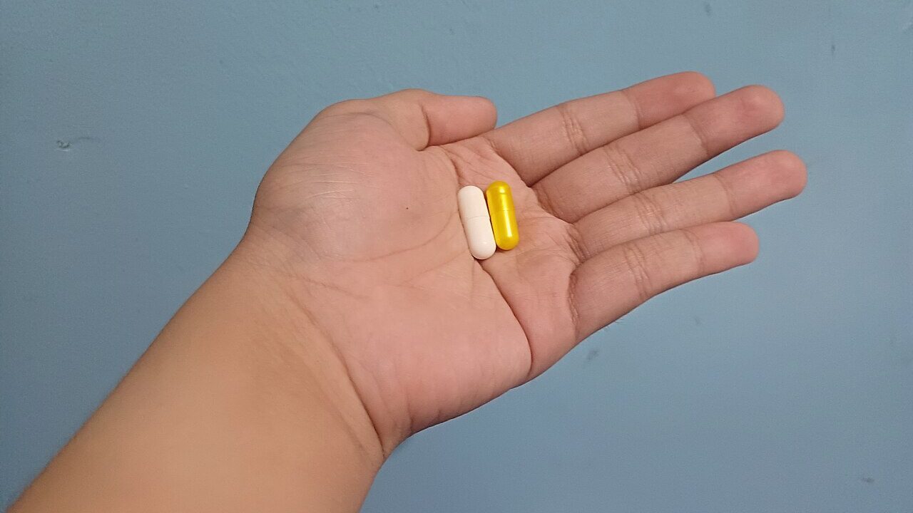 1280px A person having two capsules at home