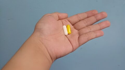 1280px A person having two capsules at home
