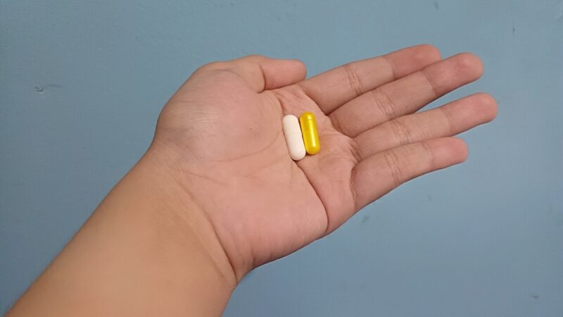 1280px A person having two capsules at home