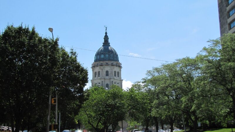 Kansas Statehouse dome rising over trees in Topeka