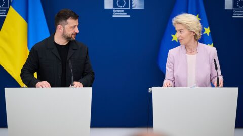 Volodymyr Zelensky speaking at a press conference with European flags